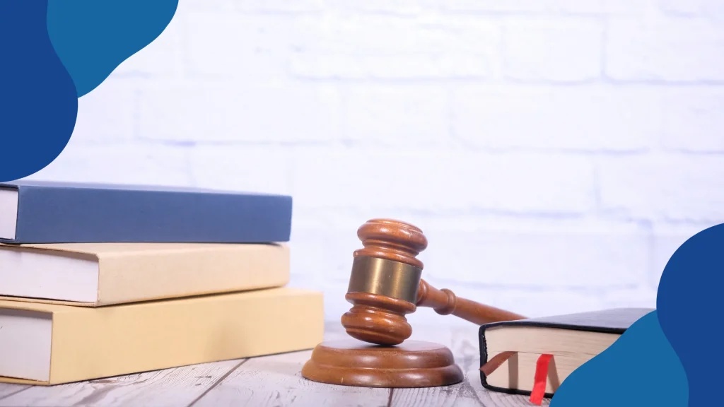 Polski Ład w pigułce, aktualizacja przepisów ustawy – młotek sędziowski na podstawce obok stosu książek