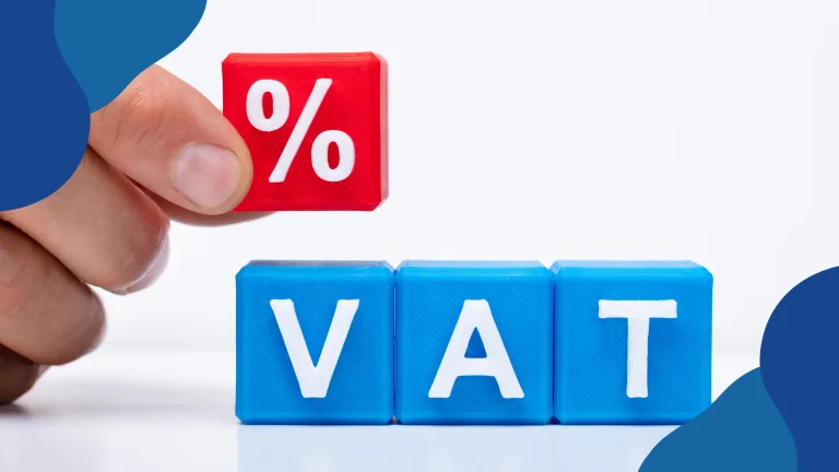 Grupy VAT od 1 stycznia 2023 roku – dłoń trzyma klocek ze znakiem procentu nad klockami z napisem „VAT”
