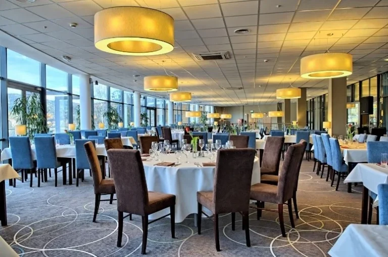 Szkolenia wyjazdowe w Krynicy-Zdroju – restauracja Hotelu Krynica z okrągłymi stołami w białych obrusach