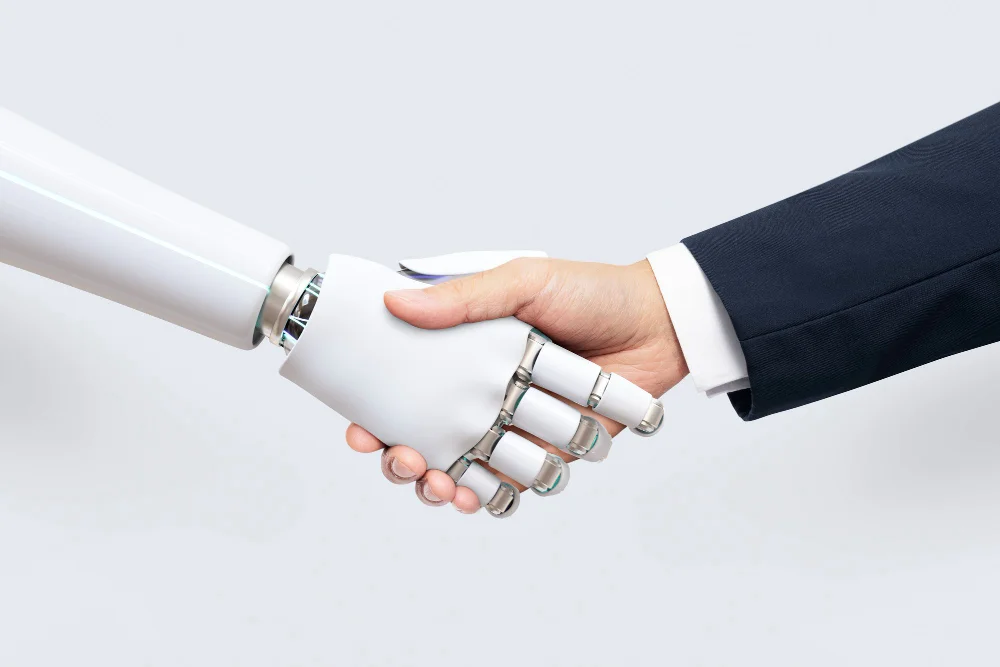 Kursy księgowe z kompetencji cyfrowych i AI – uścisk dłoni człowieka i robota na jasnym tle