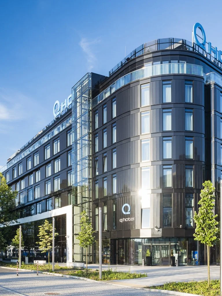 Konferencja podatkowa 2026 – Q Hotel Plus Katowice, nowoczesny budynek z logo „Q hotel” na elewacji