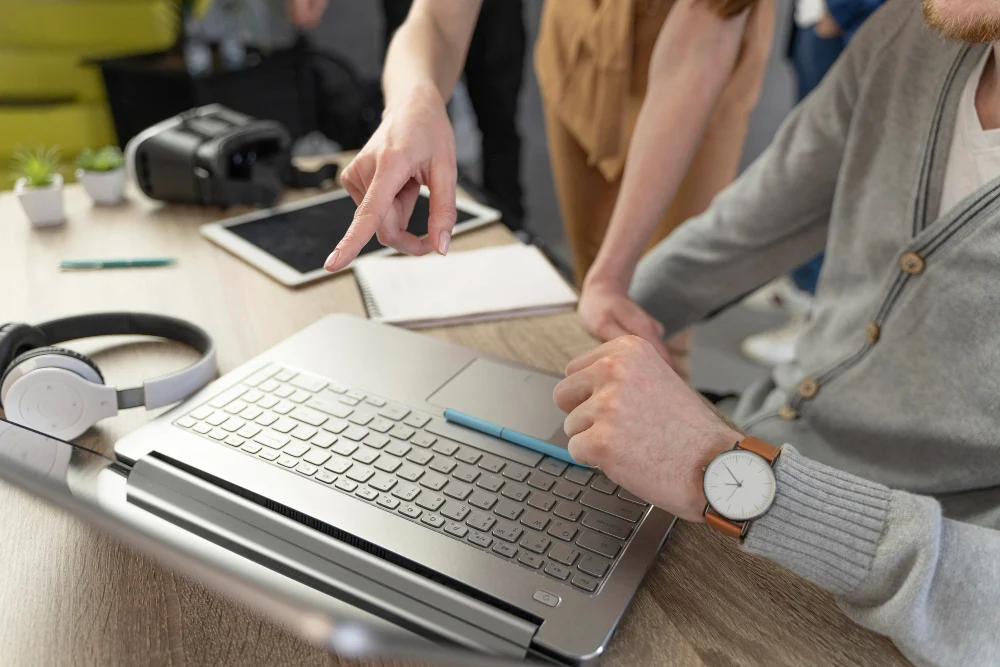 Szkolenia z kompetencji cyfrowych dla firm – praca przy laptopie i tablecie, obok gogle VR i słuchawki