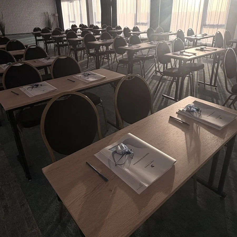 Materiały szkoleniowe Wektor Wiedzy na stołach w sali przed szkoleniem